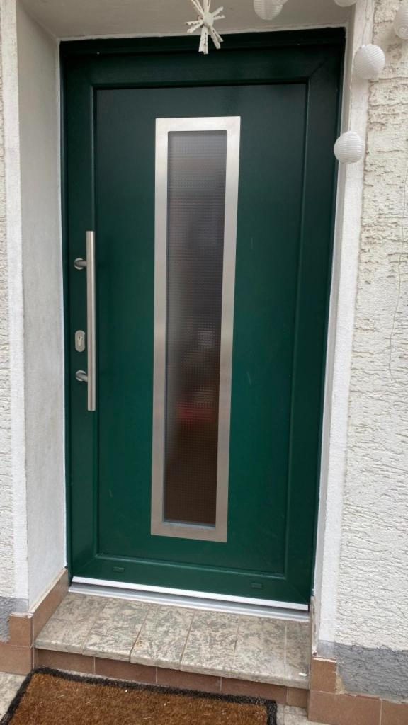 Grüne Haustür mit Edelstahlgriff